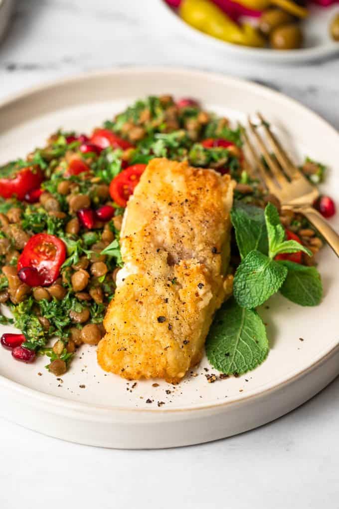 Pan-fried fish and lentil salad on a plate 