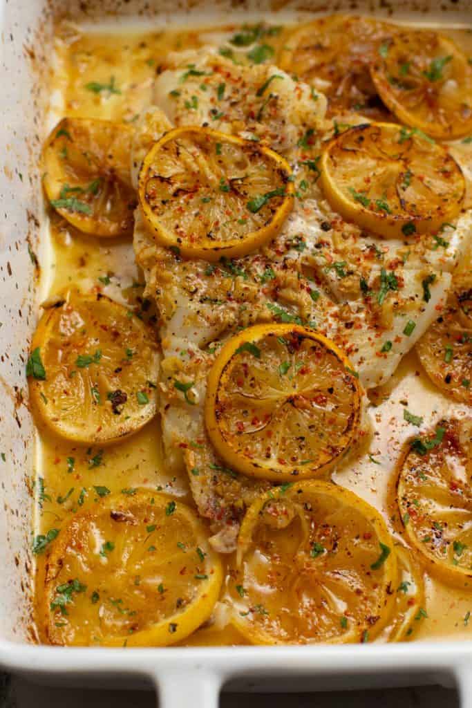 close of the garlicky lemon baked fish in a baking dish