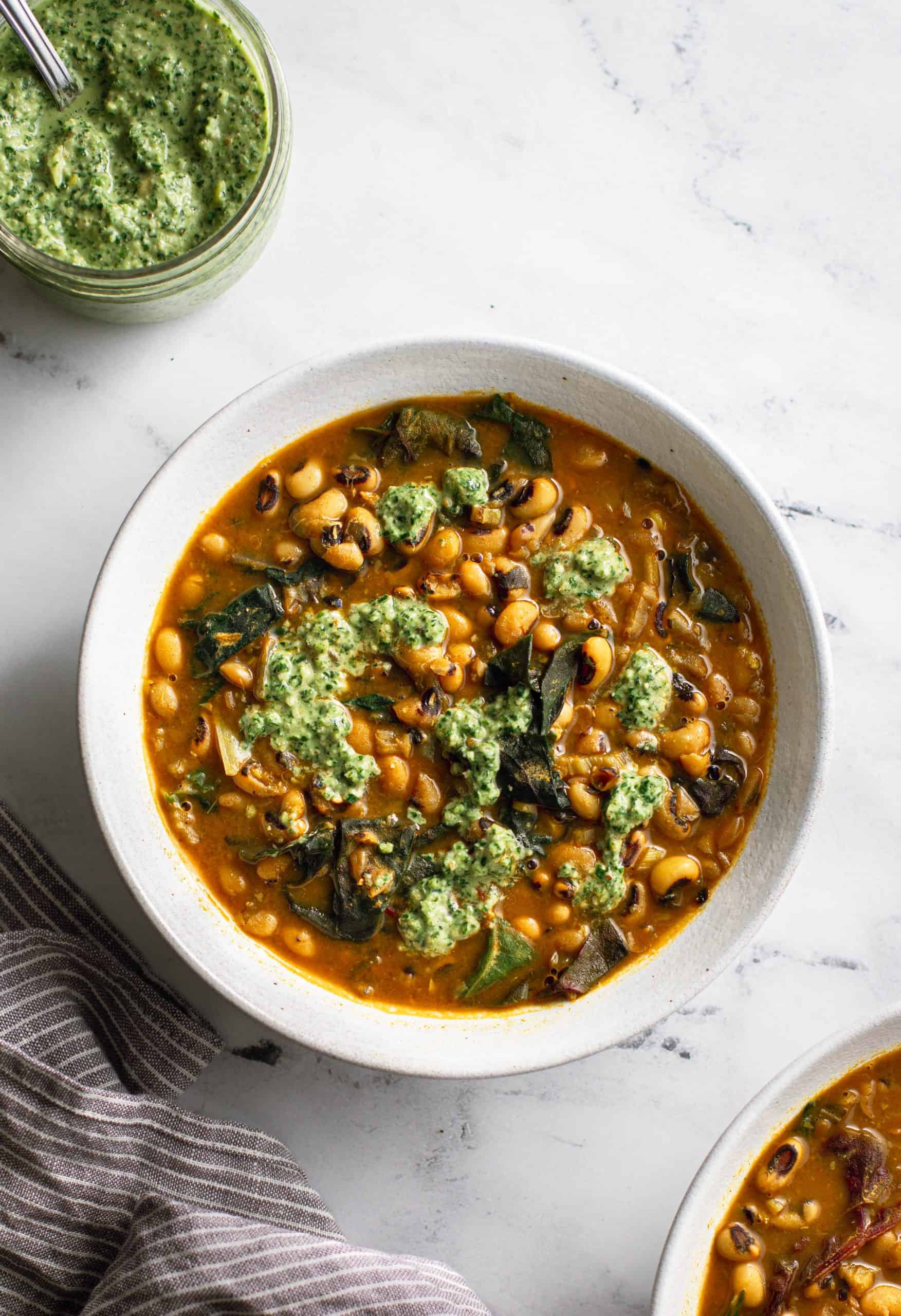 A bowl of black-eyed pea soup and herb pesto