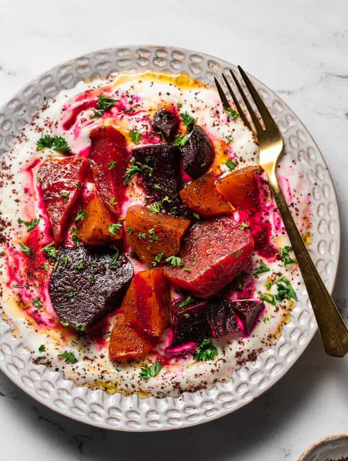 A plate filled with roasted beets and strained yogurt