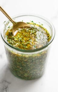 Prepared Chermoula in a jar with a spoon showing the texture of the marinade