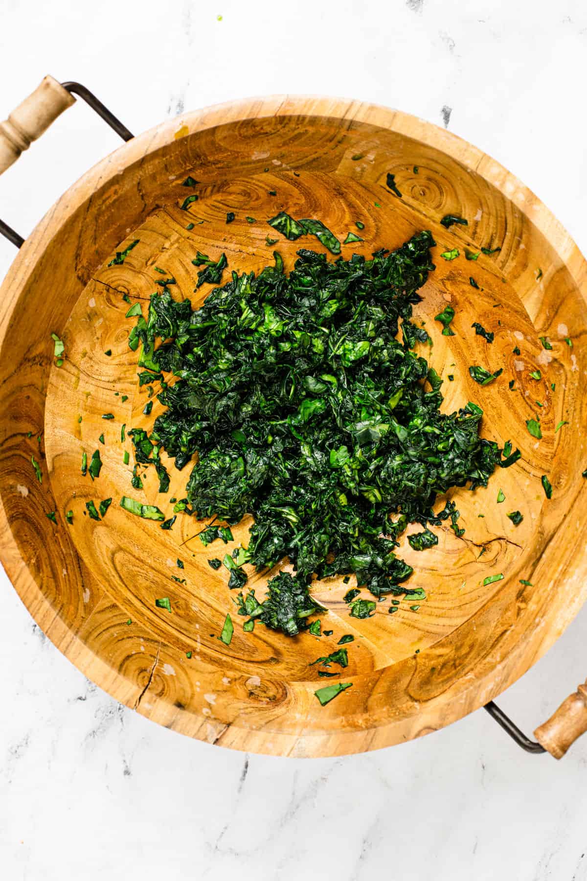 wooden bowl with fresh spinach that has been messaged
